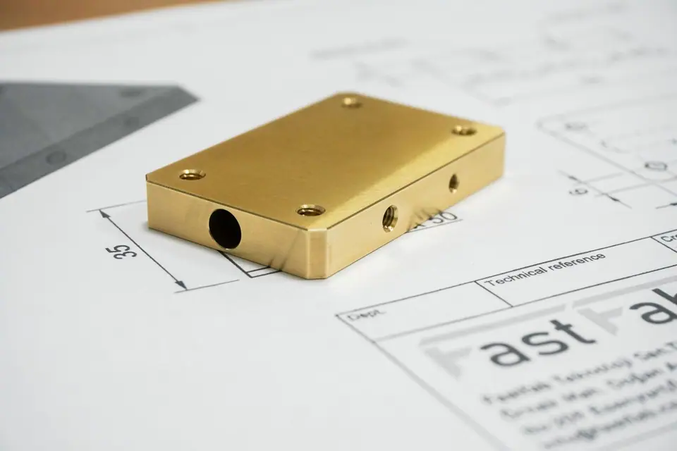 CNC-machined block with drilled ports, shown on its technical drawing